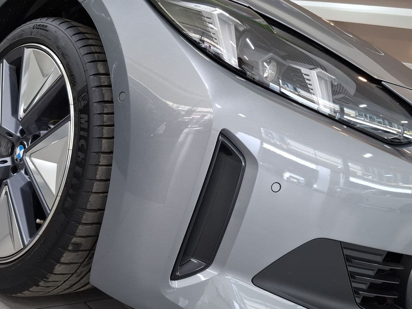 Front fender, headlight and wheel of a silver car